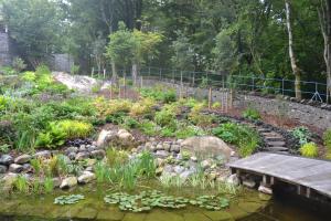 Pond and circular deck with stepping stones leading up through terraces