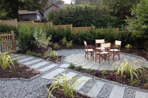 Patio with slate paving surrounded by mature Laurel hedge